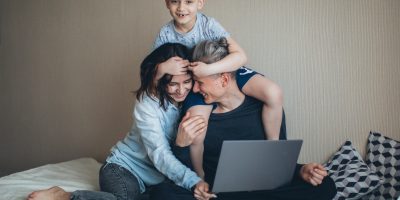 Man working remotely from home in Columbus, Ohio surrounded by his wife and young son.